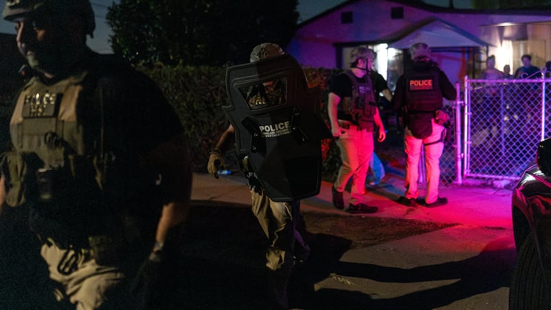 Agentes de Investigaciones de Seguridad Nacional salen de una residencia después de arrestar a...