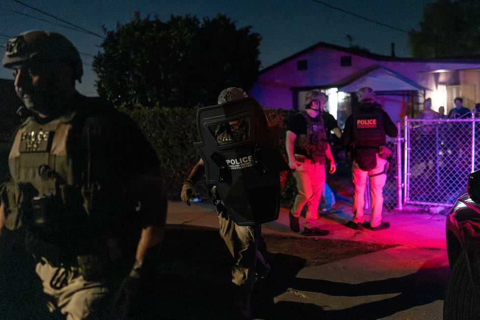 Agentes de Investigaciones de Seguridad Nacional salen de una residencia después de arrestar a...