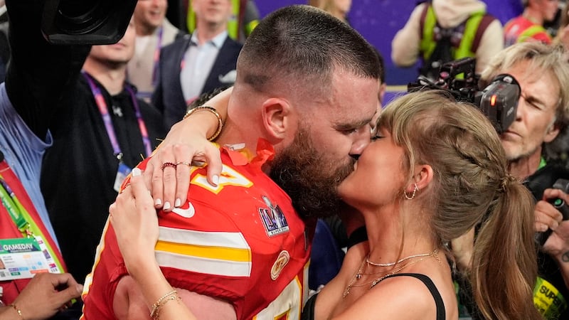 ARCHIVO - El ala cerrada de los Kansas City Chiefs, Travis Kelce (87), besa a Taylor Swift...