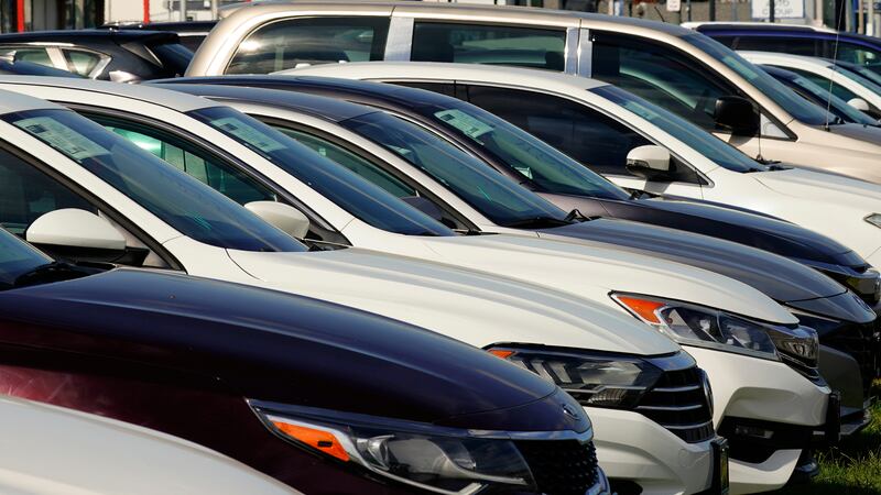 ARCHIVO - Autos a la venta bordean la carretera en un concesionario de autos usados en...