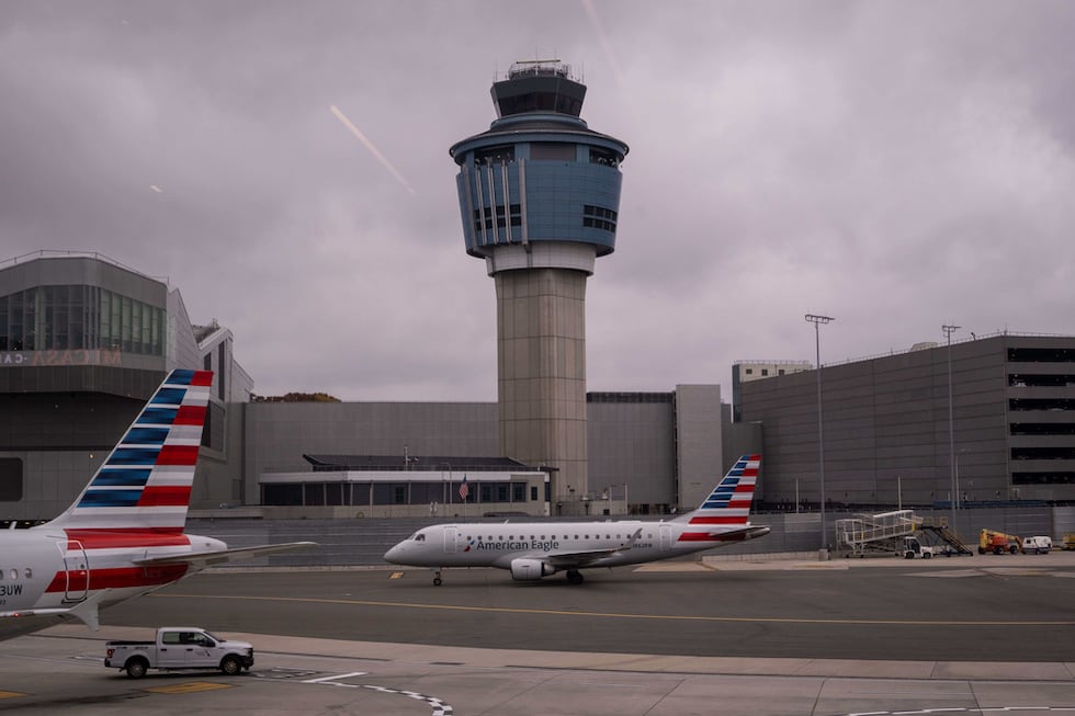 Un avión de American Eagle pasa junto a la torre de control de tráfico aéreo en el Aeropuerto...