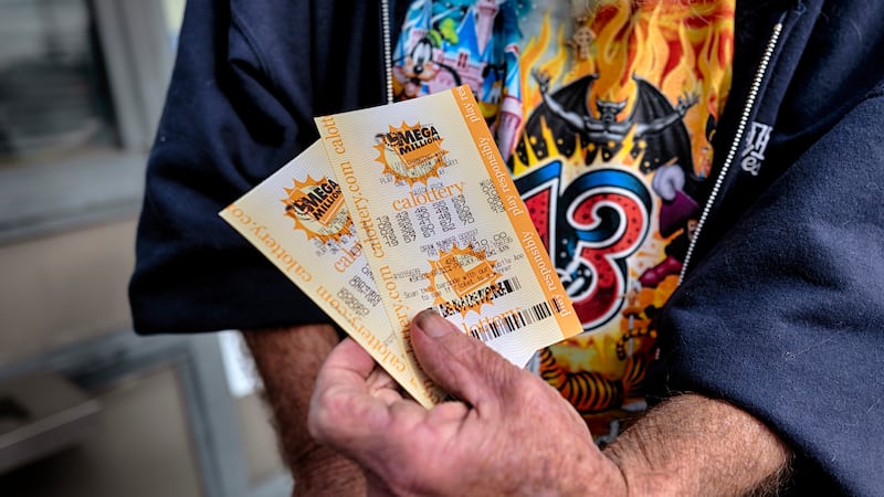 FILE - Dennis Murphy shows off his lottery tickets he bought at Joe's Service Center on...