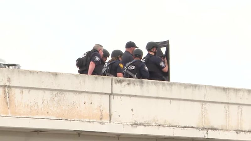 Un hombre se montó en el borde de un puente en la Interestatal 35 en San Antonio, Texas, y...
